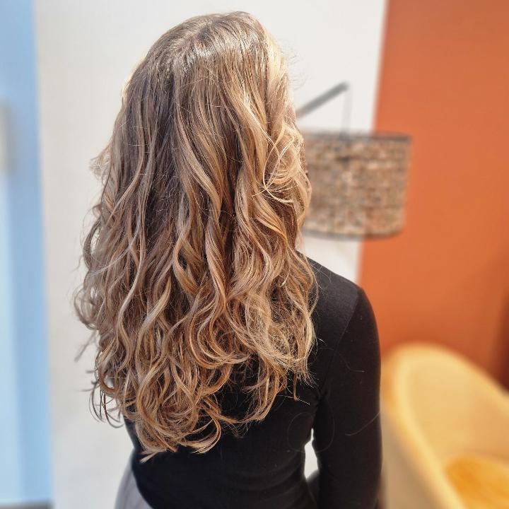 Balayage Lumière mis en valeur par des boucles naturelles